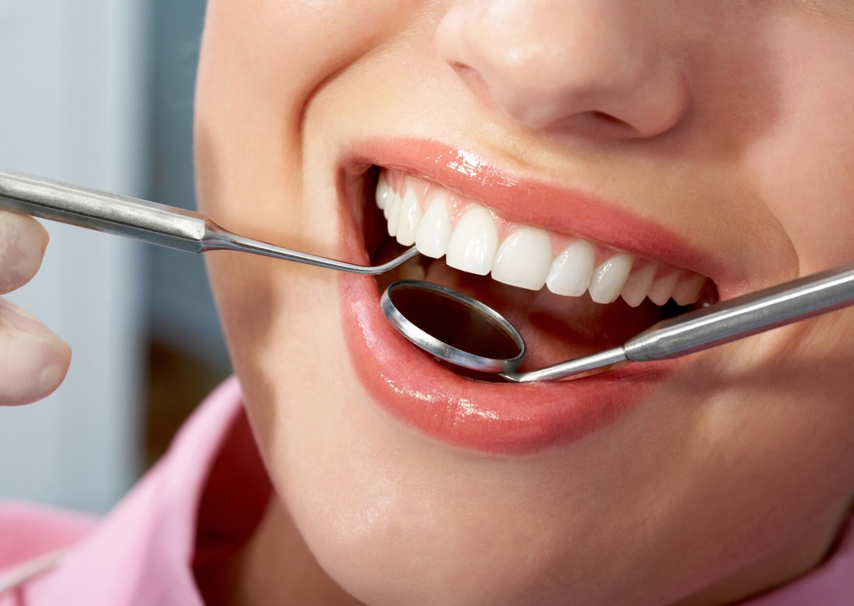 Close-up of healthy porcelain veneers during a dental exam, illustrating how proper care can extend veneers lifespan.