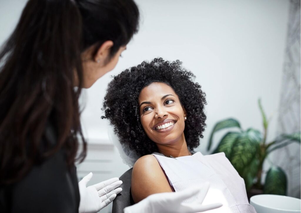 Patient discussing professional whitening options with a dentist after considering the effectiveness of teeth whitening strips.
