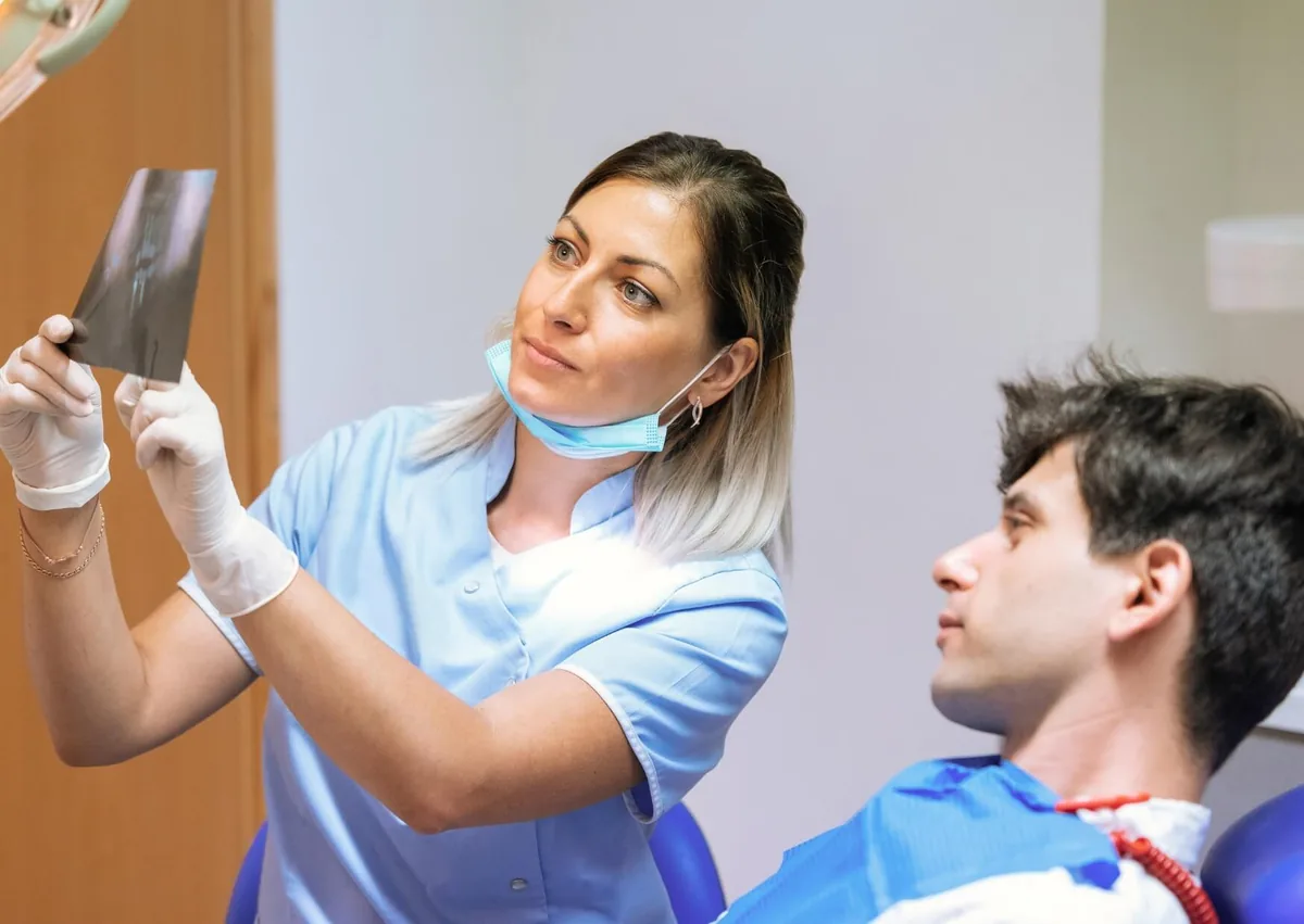 Dentist reviewing a dental X-ray with a patient while planning affordable dental implant treatment.