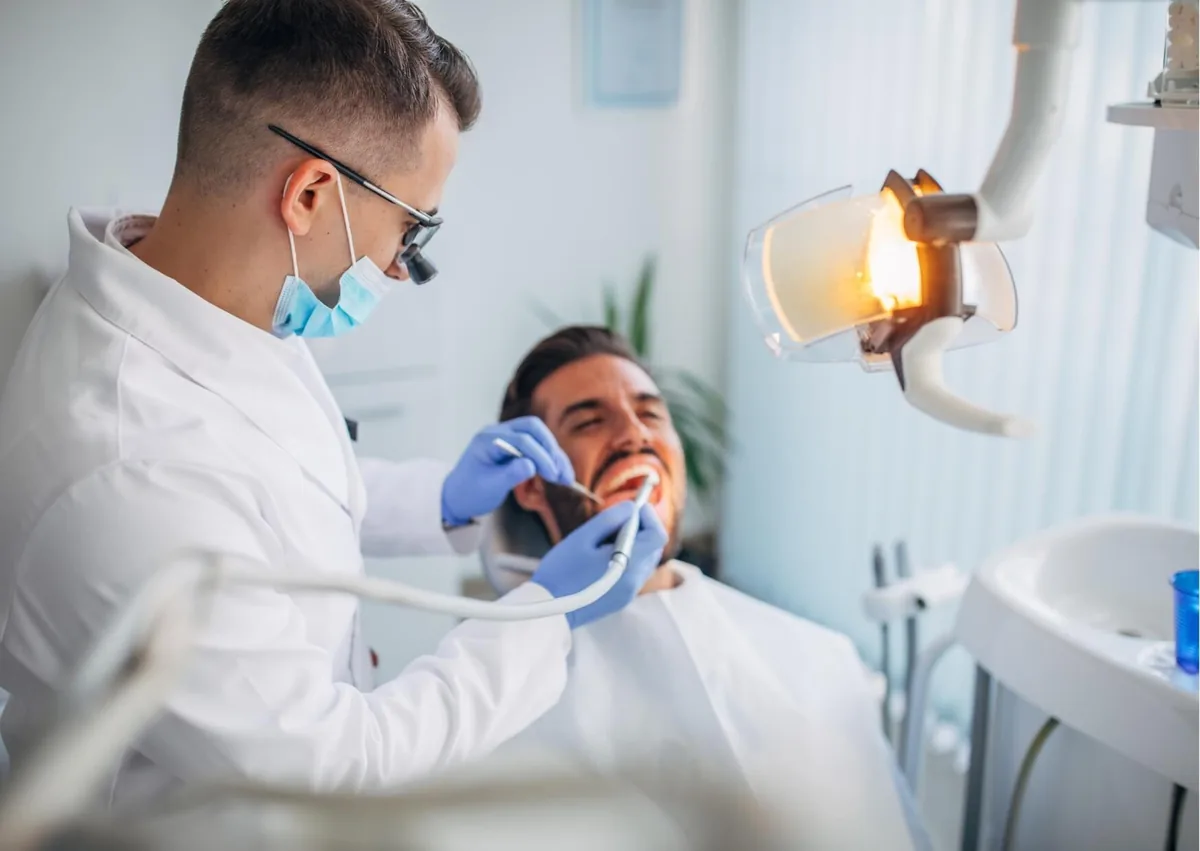 Dentist performing a routine cleaning as part of preventive dental care for a patient.