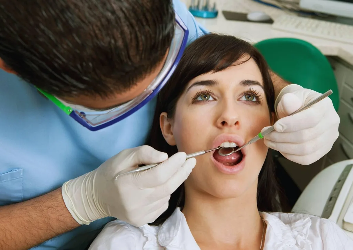 Dentist examining a patient for oral health concerns related to dry mouth.